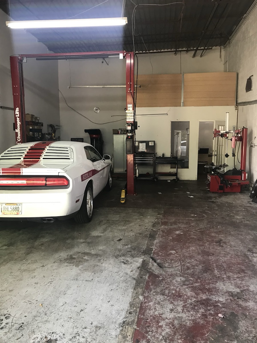 A car up on the two-post lift in the ATL Mobile Auto Repair service bay